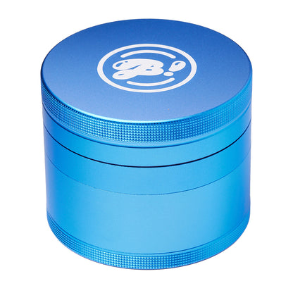 Blue aluminum herb grinder with textured grip and white logo on top, isolated on white background.