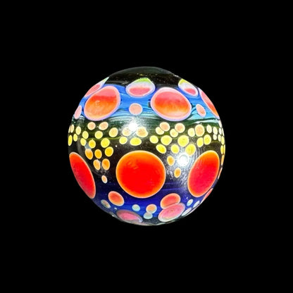 Heady glass marble with vibrant orange, yellow, and blue dot patterns on black background