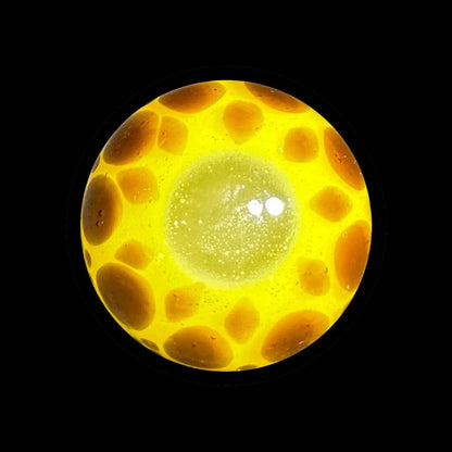 Yellow and orange glass marble carb cap with honeycomb pattern on black background