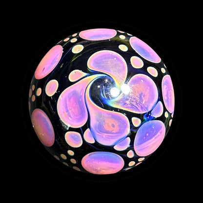 Heady glass marble with vibrant pink and purple swirl design on black background