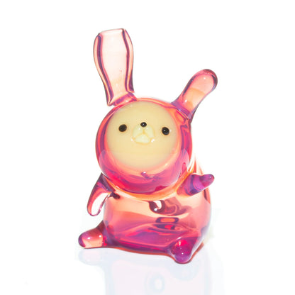 Pink and yellow glass animal carb cap with upright ears and cute face, on white background