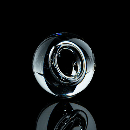Clear toroidal glass marble with reflective finish on black background