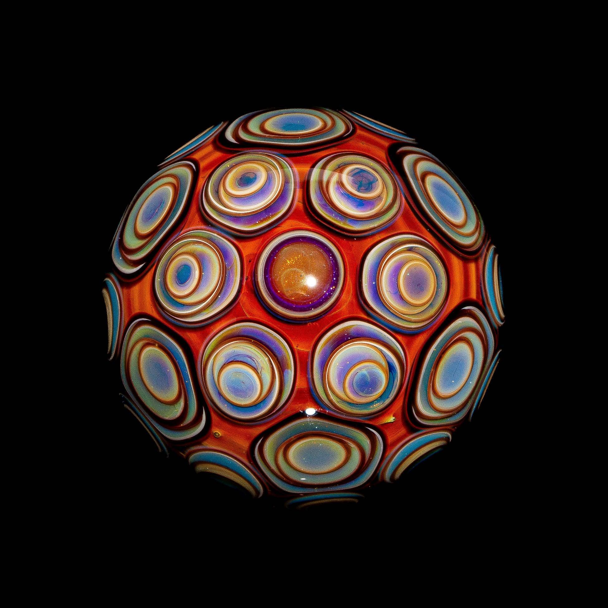 Hand-blown glass sphere with vibrant, colorful concentric circle designs on black background