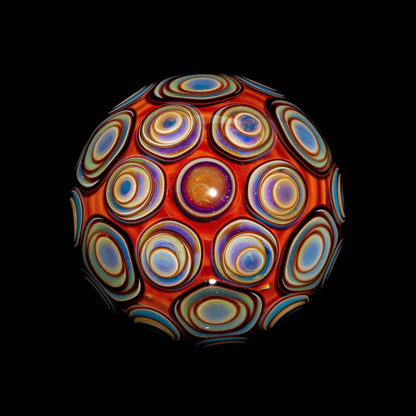Hand-blown glass sphere with vibrant, colorful concentric circle designs on black background