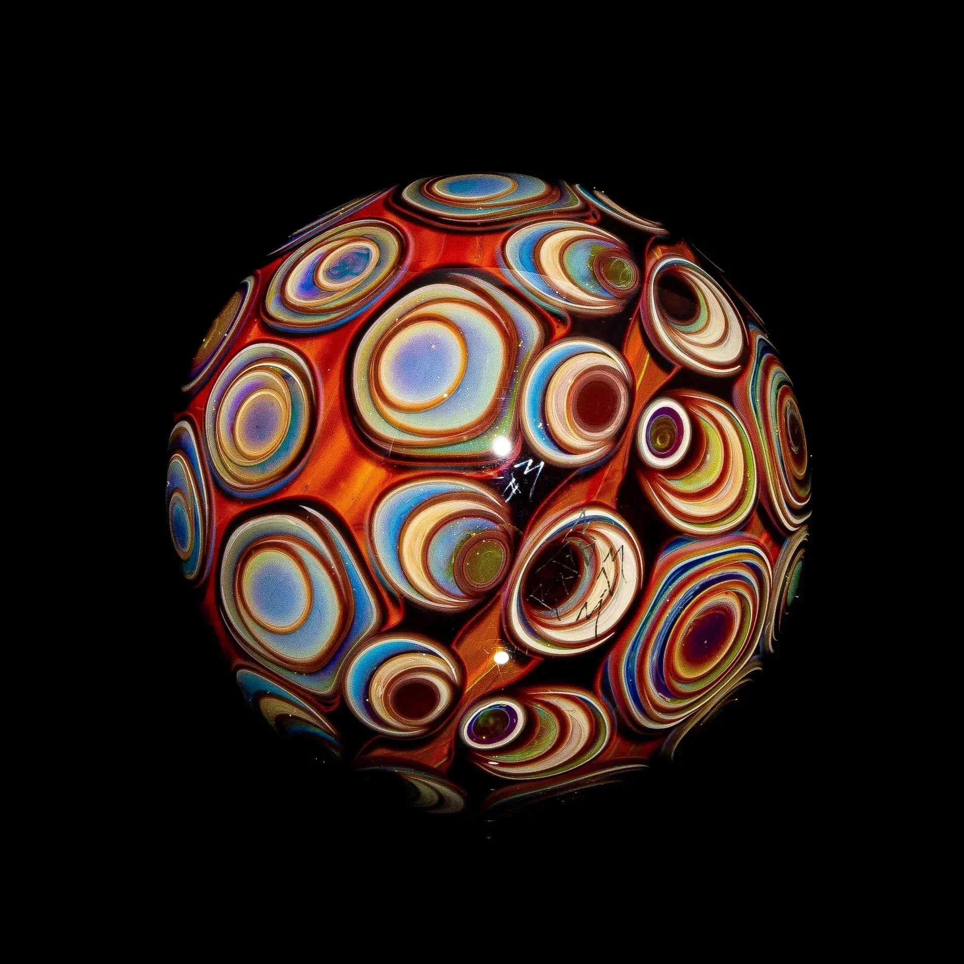 Heady glass art sphere with vibrant, layered bullseye patterns on black background