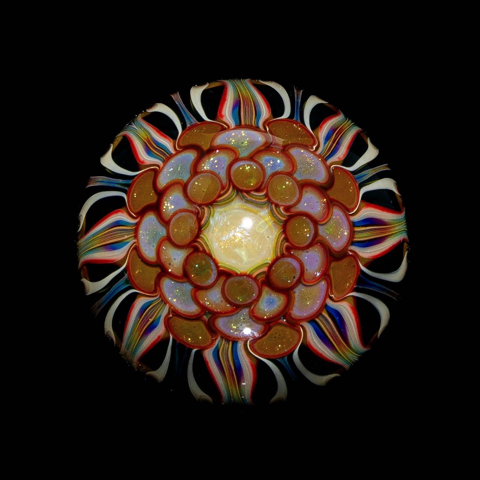 Intricate glass art piece with colorful spiral and layered flower-like patterns on black background