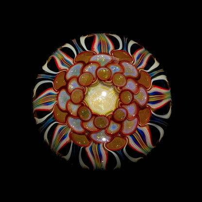 Intricate glass art piece with colorful spiral and layered flower-like patterns on black background