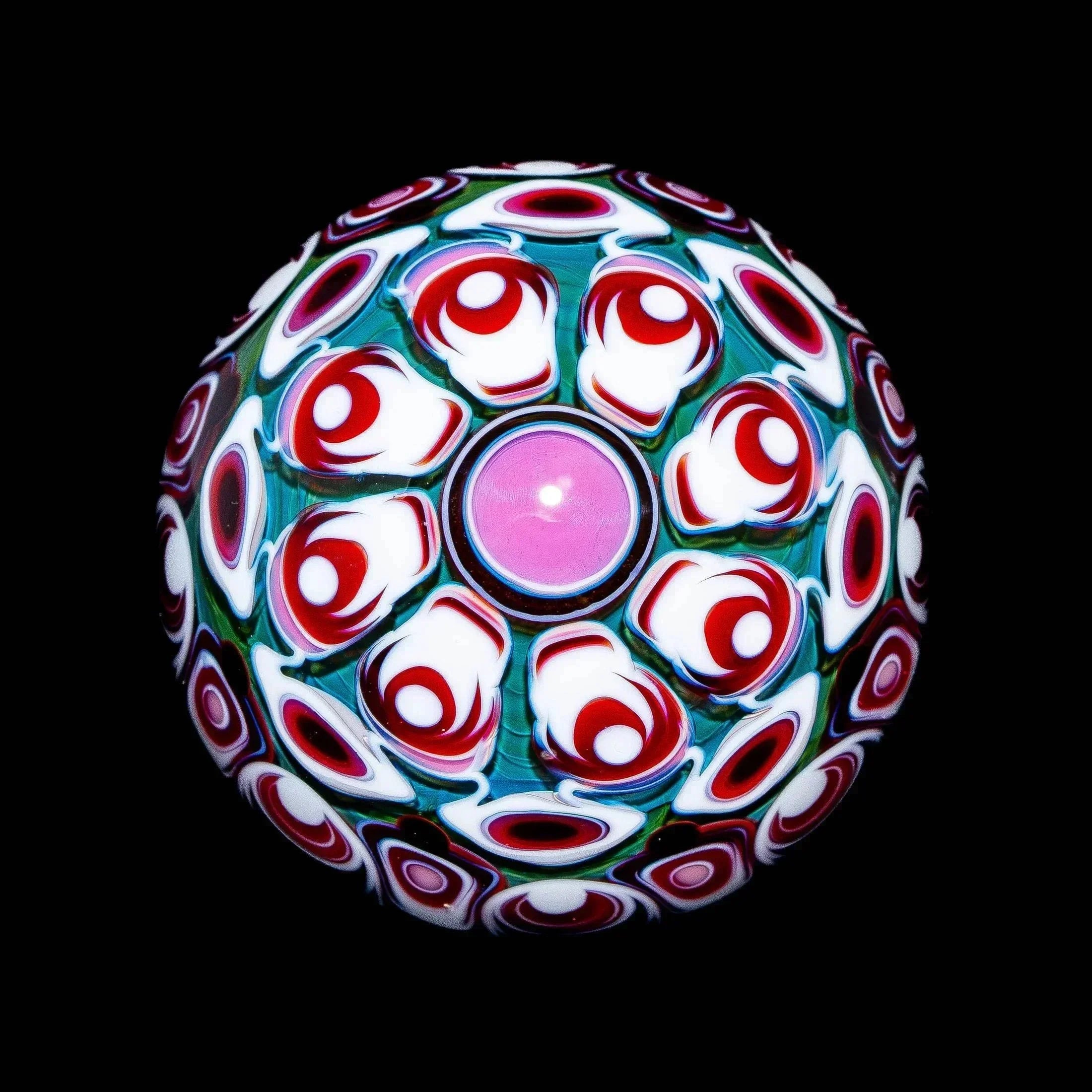 intricate borosilicate glass marble with vibrant red, white, and green patterns on black background