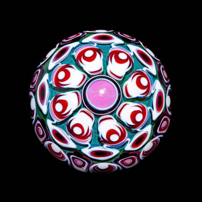 intricate borosilicate glass marble with vibrant red, white, and green patterns on black background