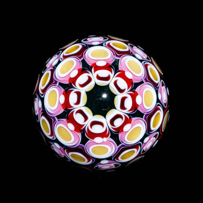 Colorful heady glass marble featuring intricate cane patterns on a black background