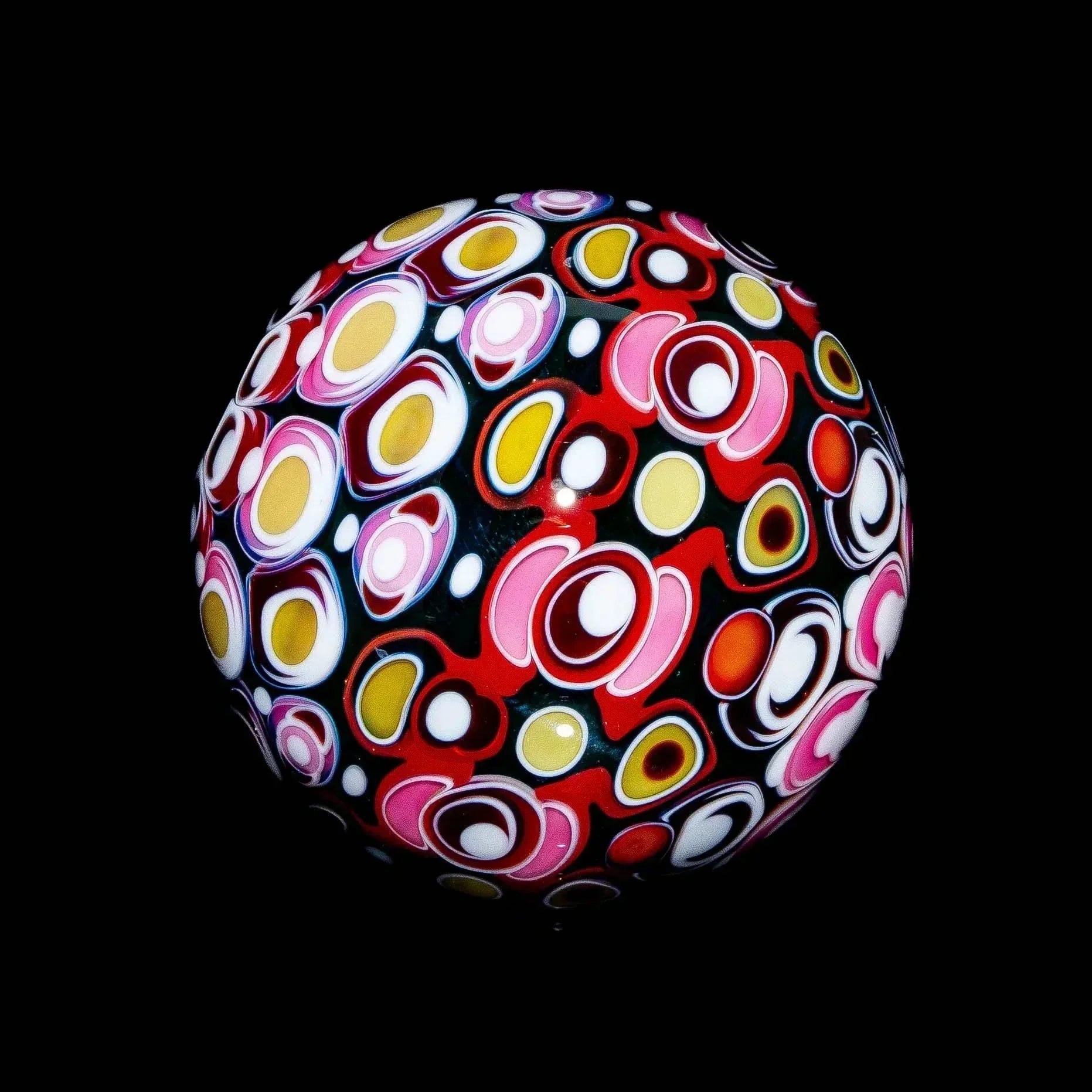 Colorful heady glass marble with intricate abstract patterns on a black background.