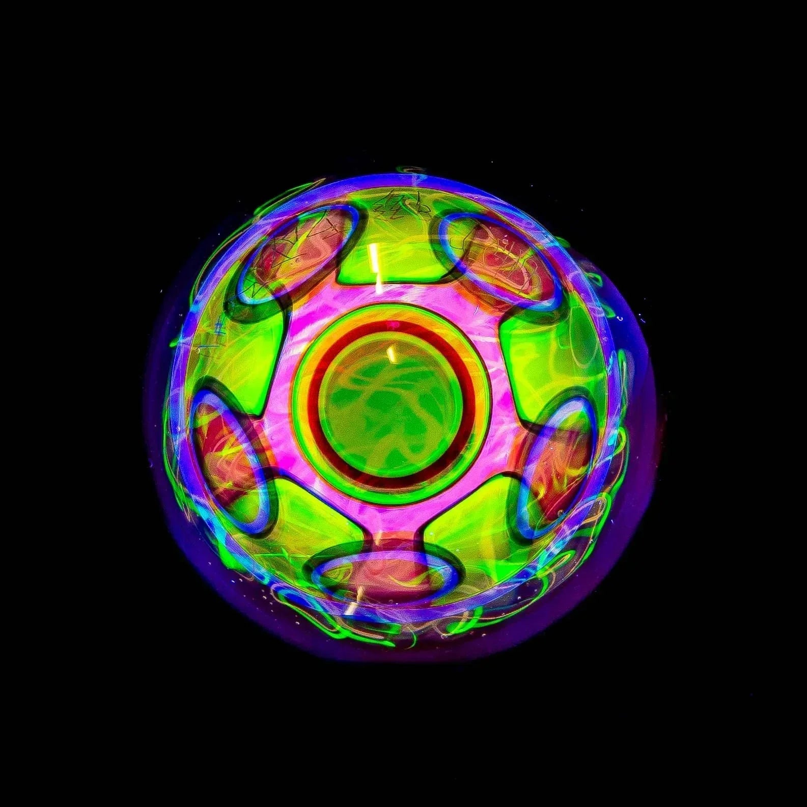 Heady glass art sphere with neon green, pink, and blue patterns on black background