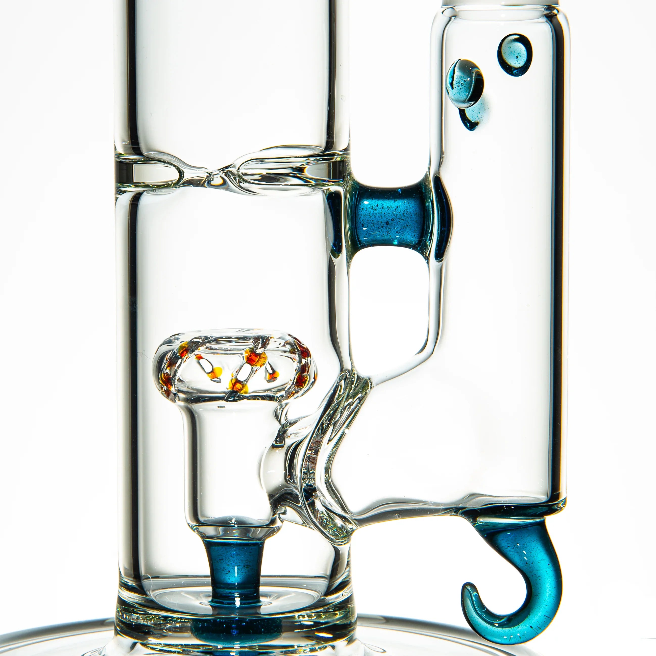 Close-up of clear glass water pipe with blue stardust accents and intricate glasswork.