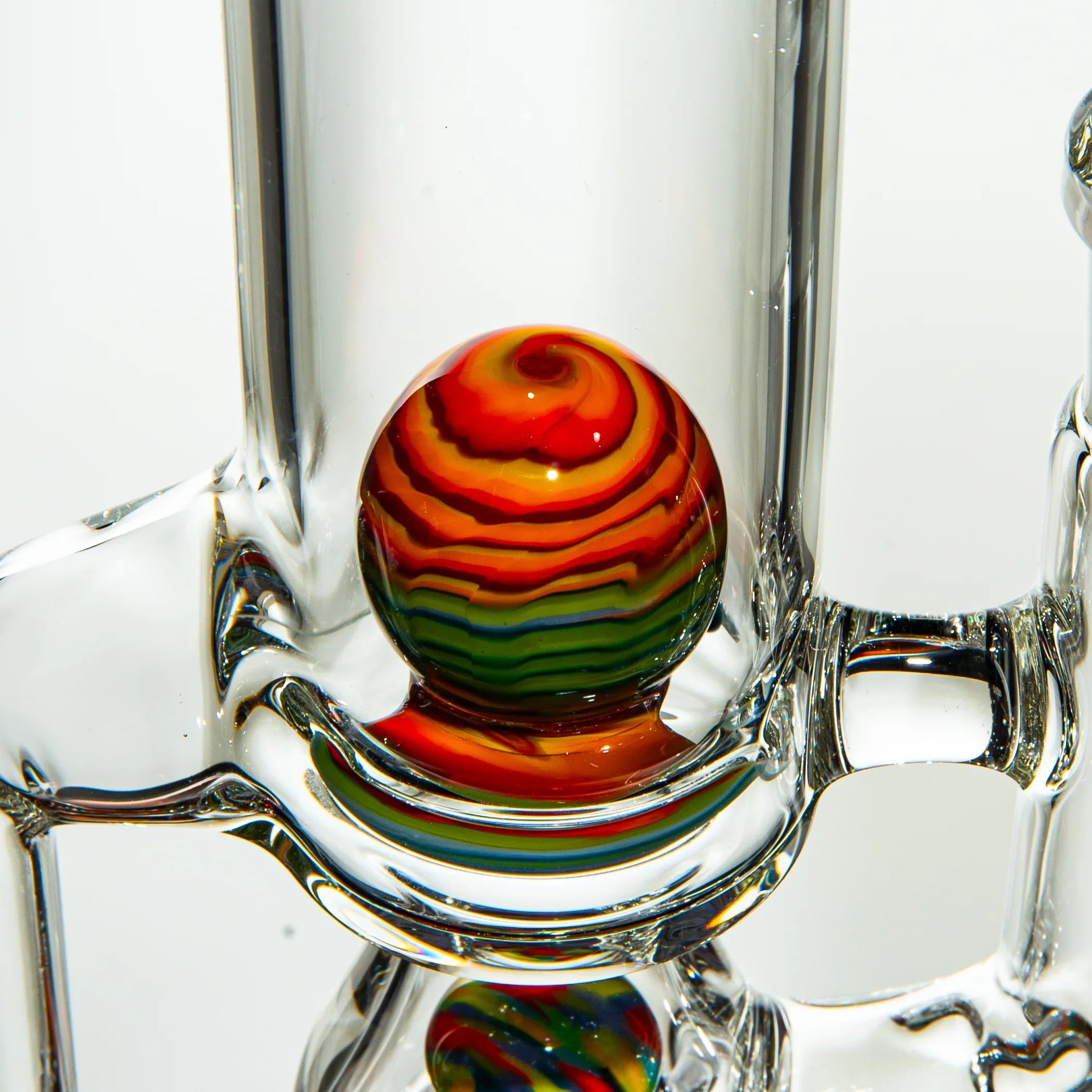 Close-up of a heady glass water pipe with a vibrant rainbow swirl marble accent.