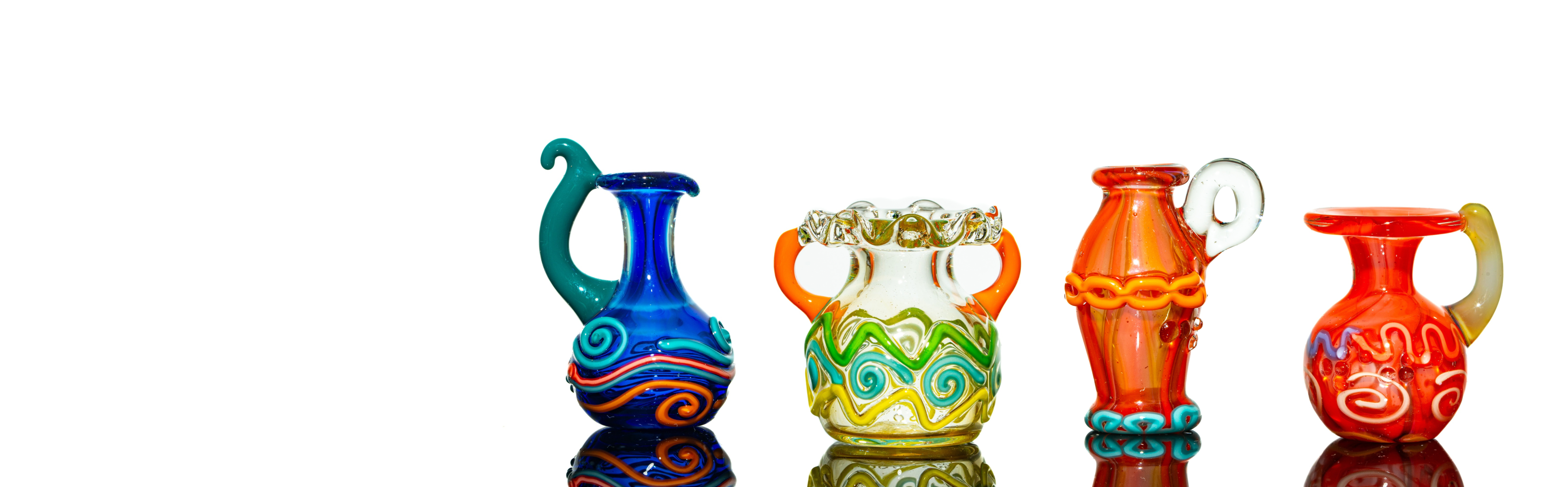 Four colorful glass vases with intricate designs on a white background