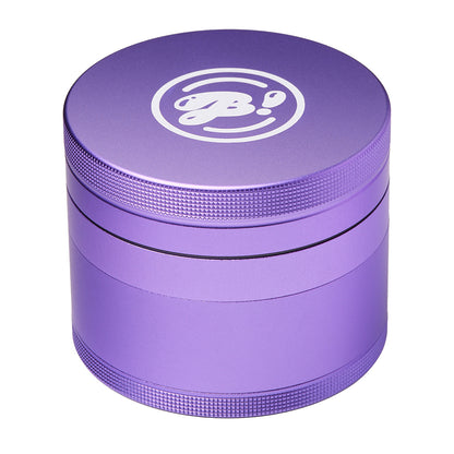 Purple metal herb grinder with textured grip and logo on the lid, isolated on white