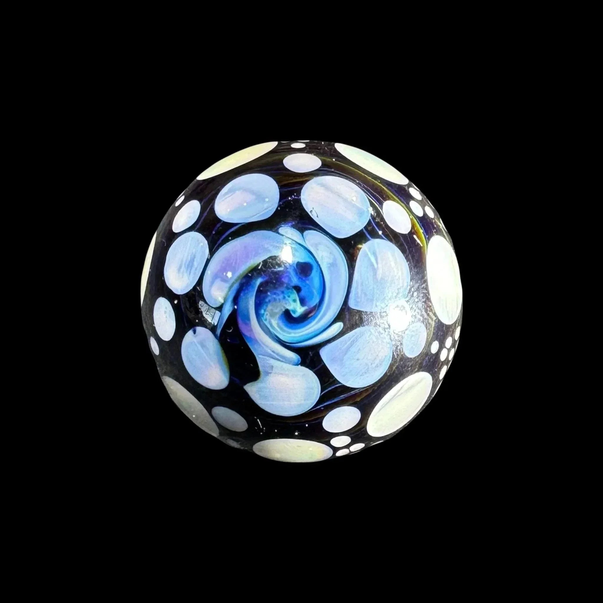 Heady glass marble with blue swirl and white polka dot patterns on black background