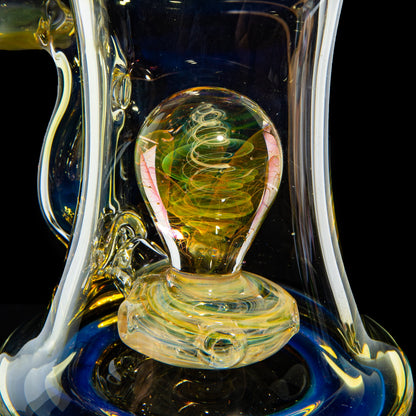 Close-up of a hand-blown glass water pipe with intricate swirling designs and colorful details