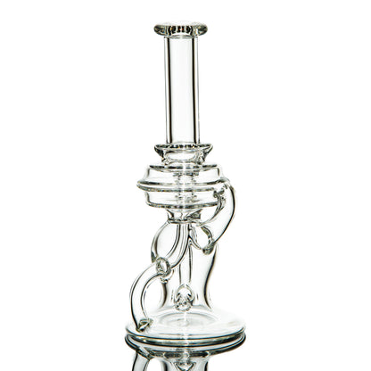 Clear heady glass water pipe with intricate recycler design on white background