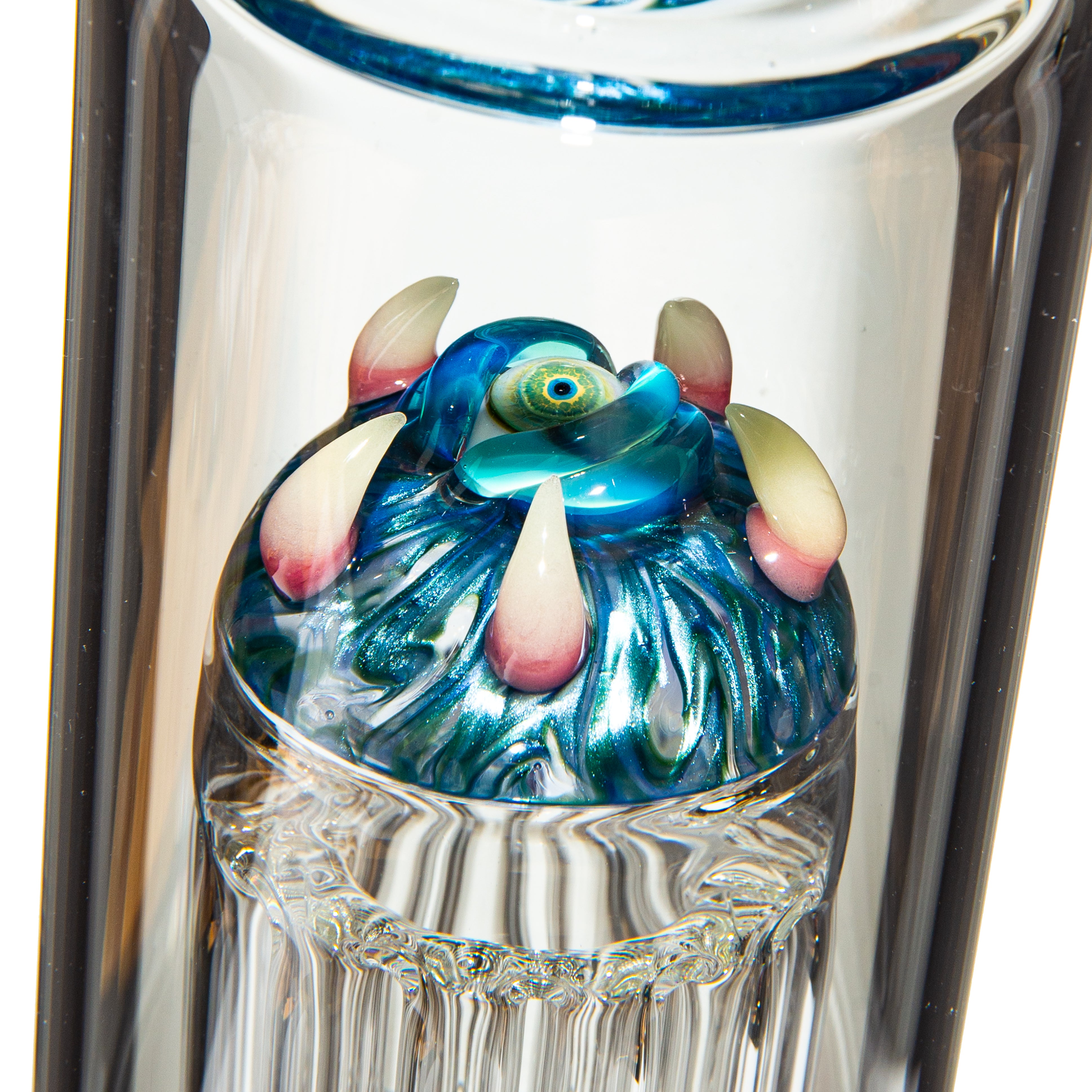 Close-up of artistic glass bong with colorful sculpted monster eye and claws detail