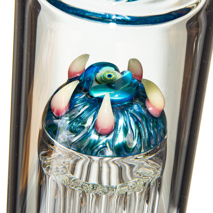 Close-up of artistic glass bong with colorful sculpted monster eye and claws detail