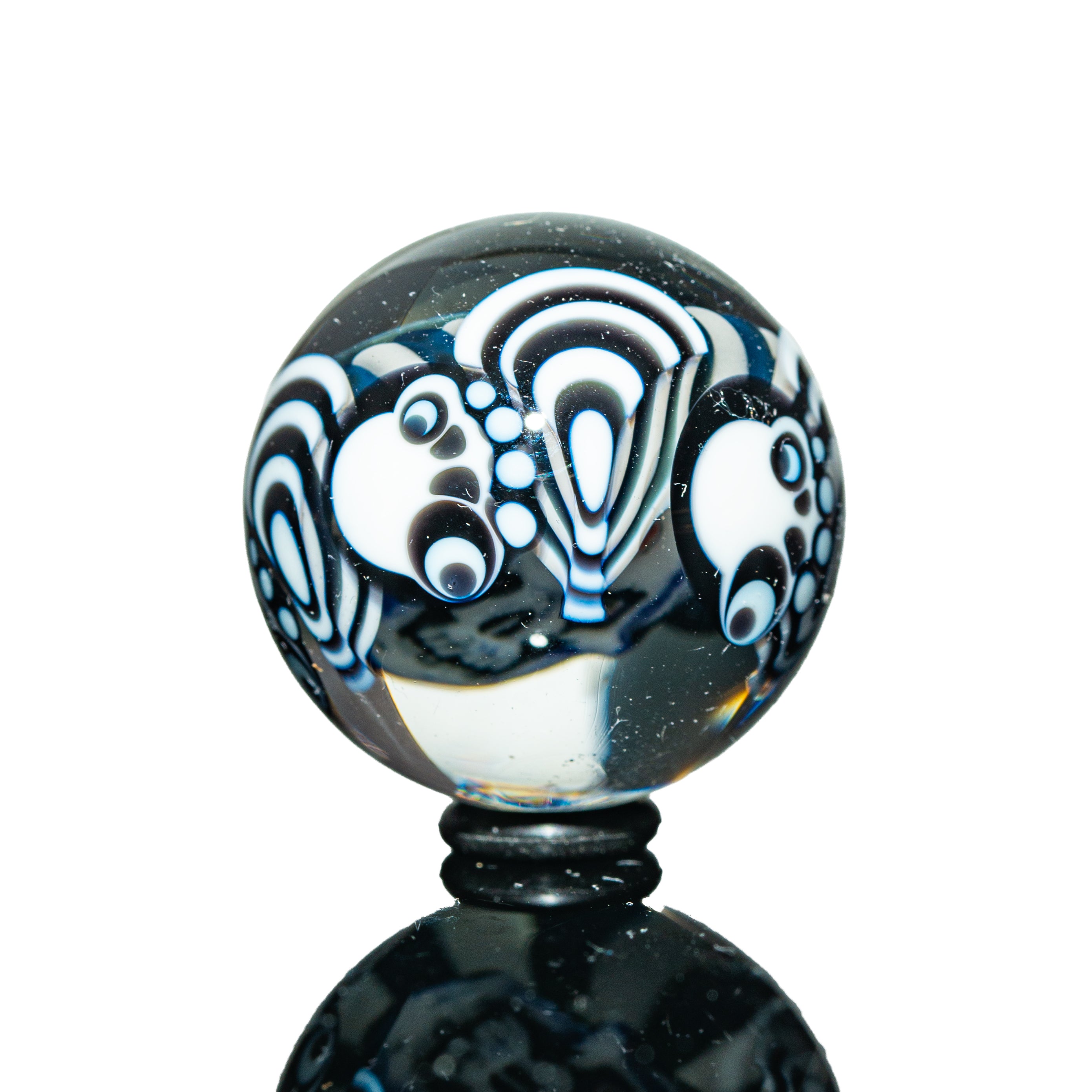Glass marble with black and white psychedelic patterns, detailed dot and wave designs