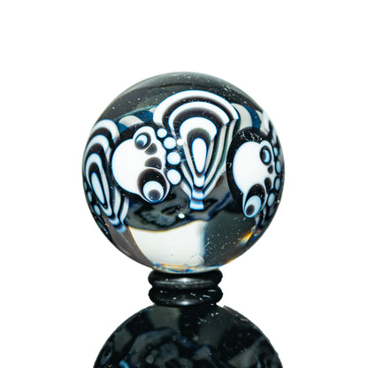 Glass marble with black and white psychedelic patterns, detailed dot and wave designs