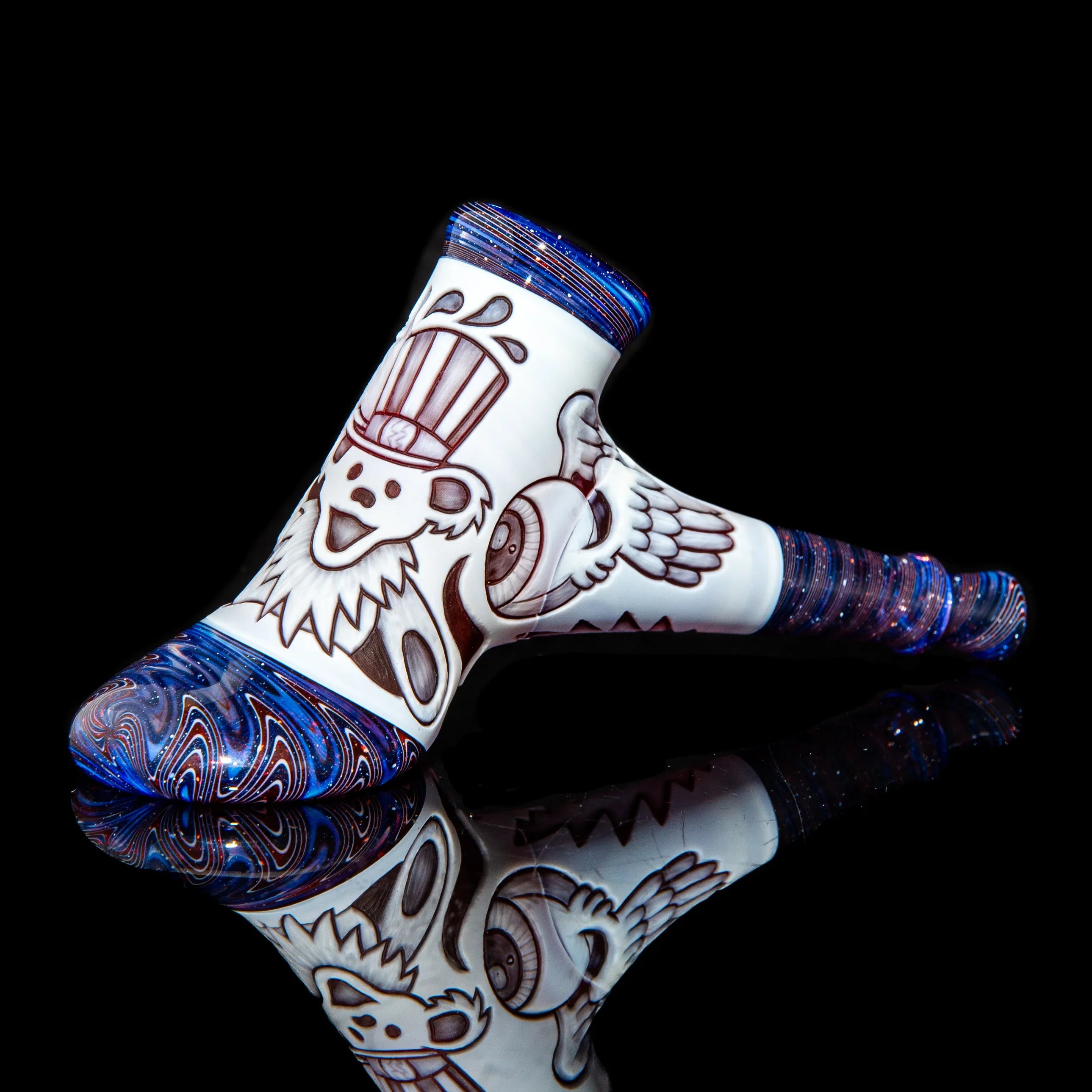 Heady glass pipe with blue swirls and detailed bear and winged eye designs on white background