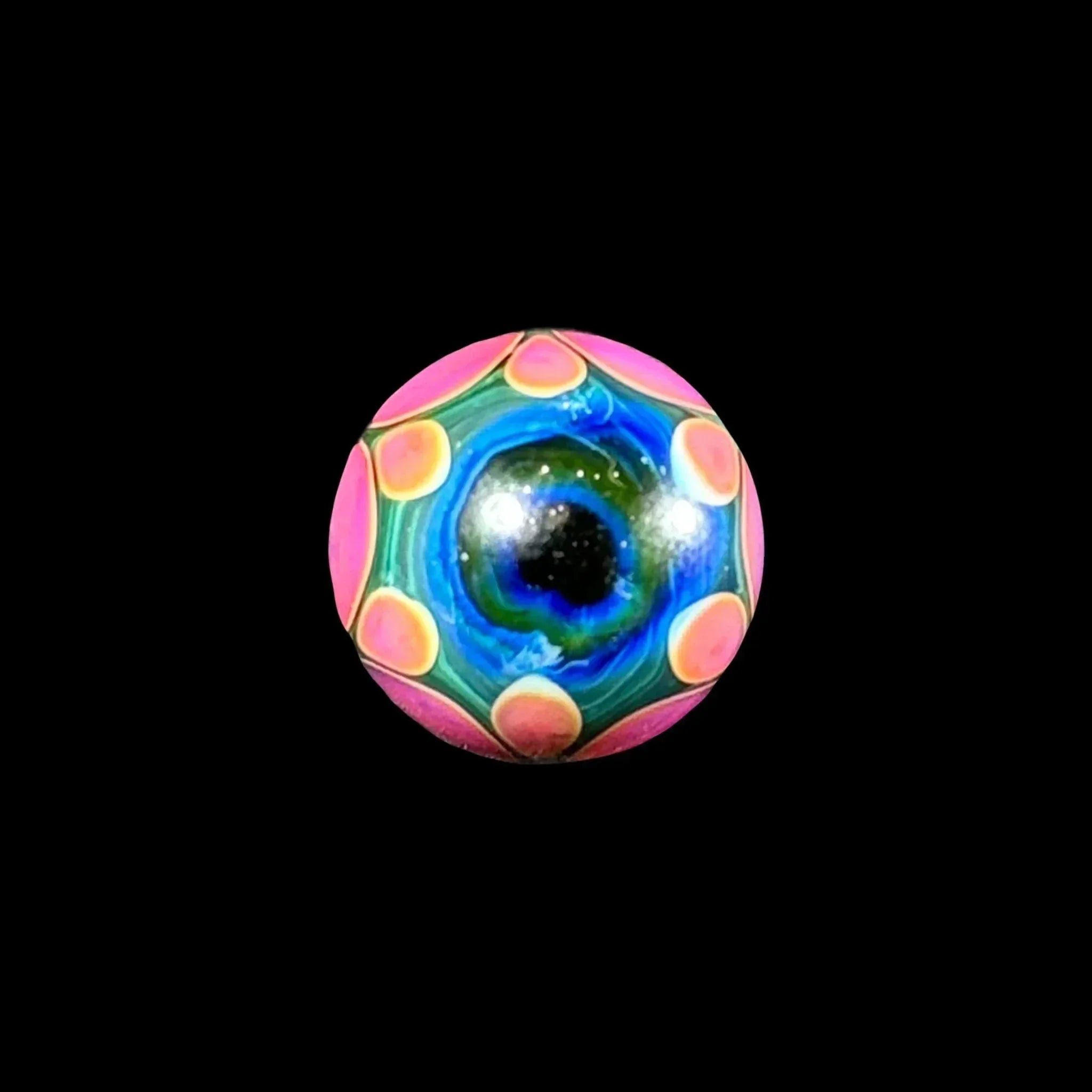 Colorful glass marble with blue, green, and pink patterns, isolated on black background