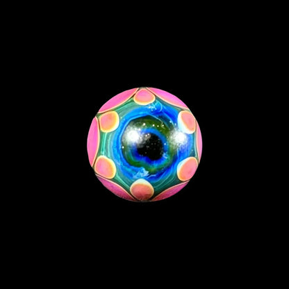Colorful glass marble with blue, green, and pink patterns, isolated on black background