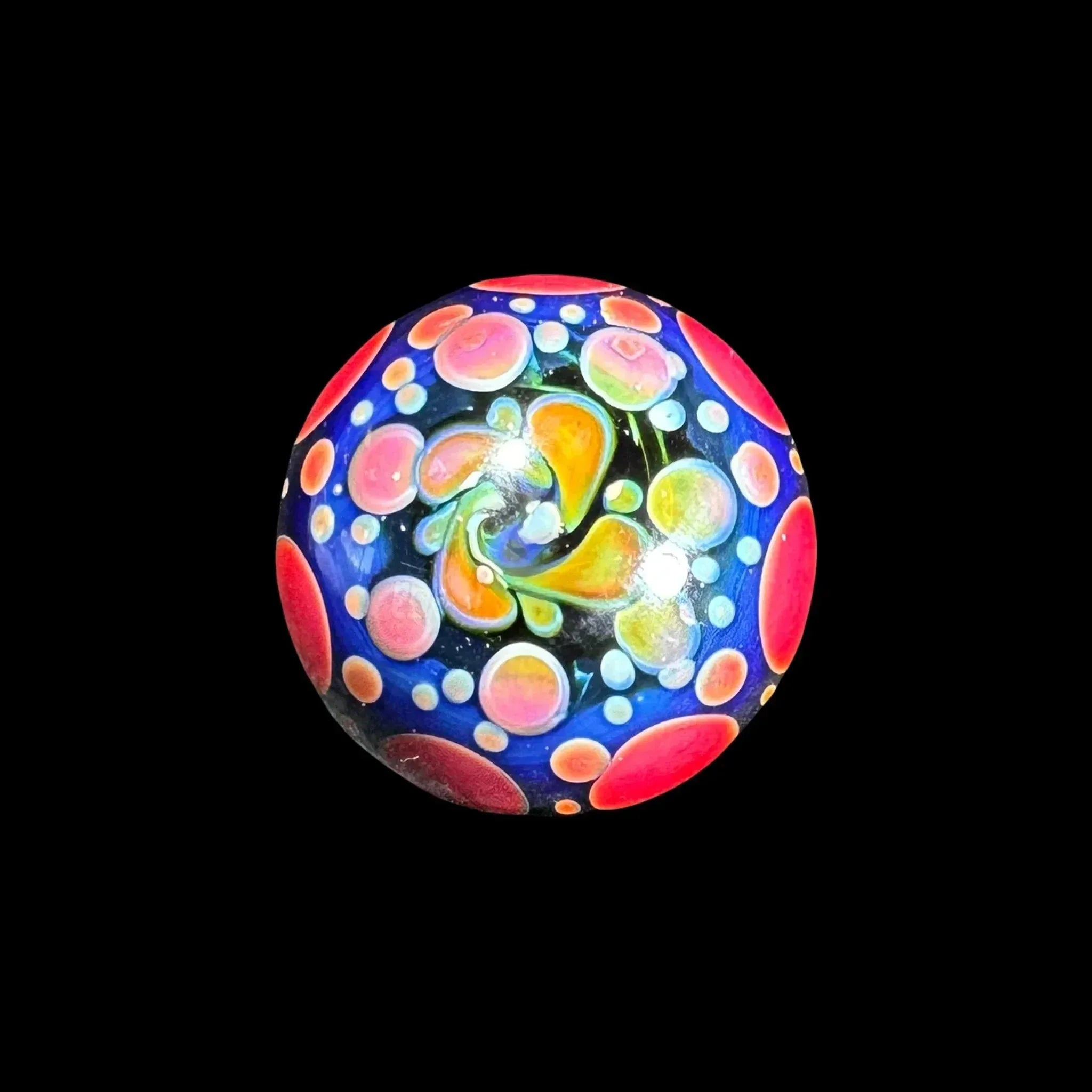 Colorful glass marble with swirling abstract dots and vibrant patterns on black background