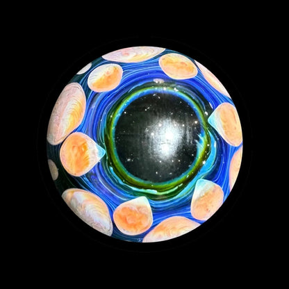 Intricate glass marble with swirling blue, green, and orange patterns on a black background