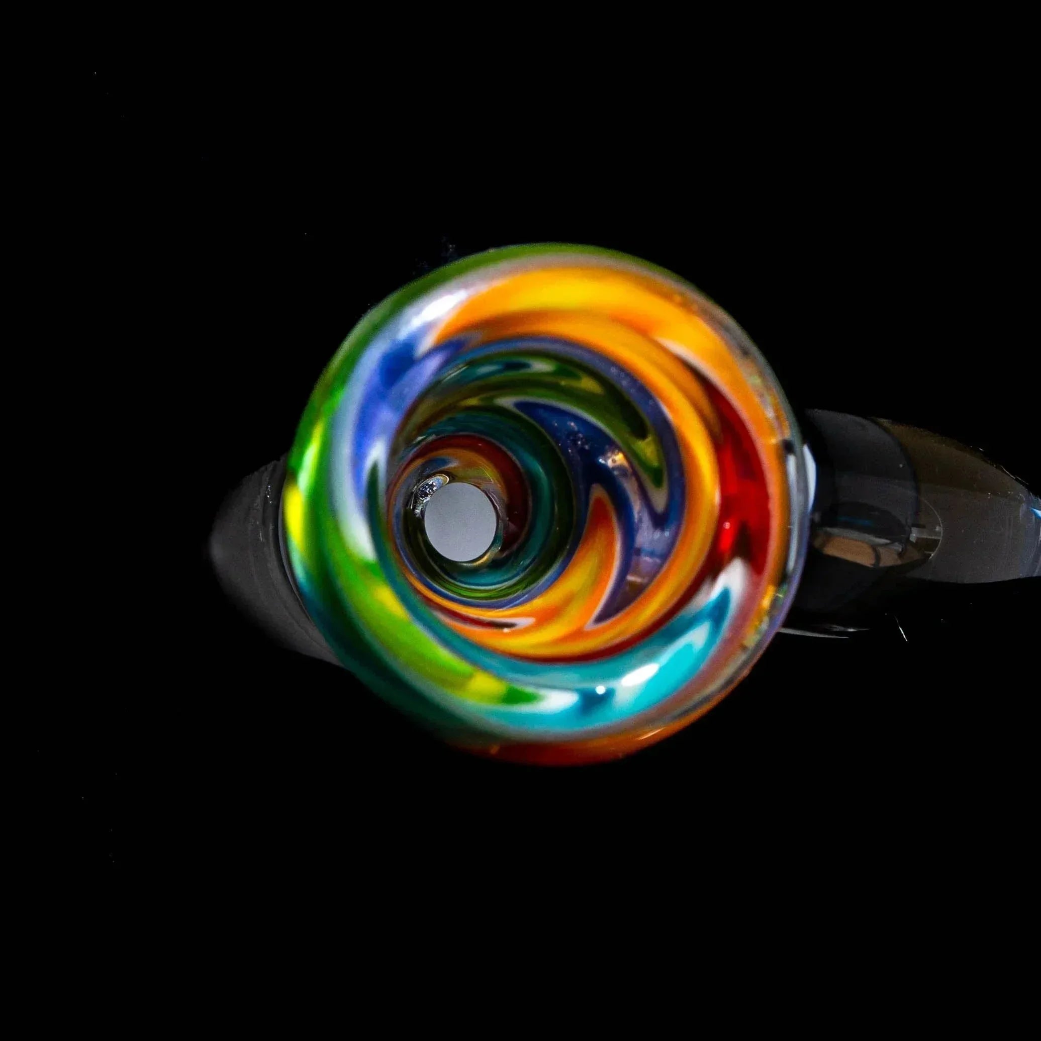Colorful glass slide bowl with purple, green, and blue wig wag spiral design on black