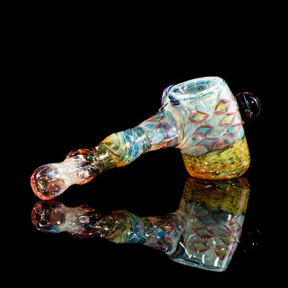 Handcrafted colorful glass pipe with intricate patterns on a black reflective surface