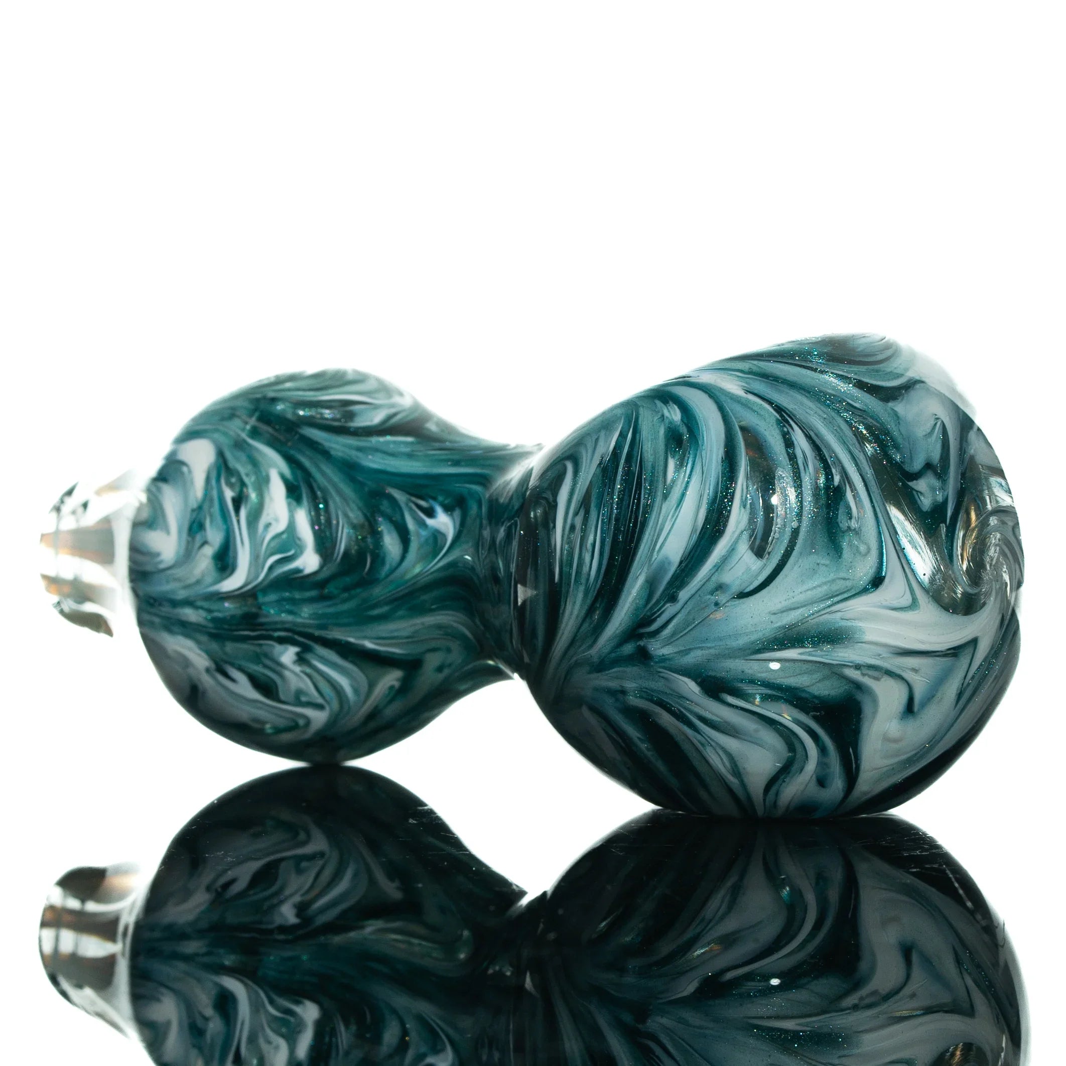 Hand-blown glass spoon pipe with blue and white swirling patterns on reflective surface