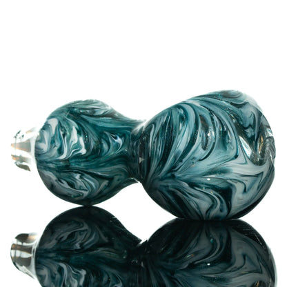 Hand-blown glass spoon pipe with blue and white swirling patterns on reflective surface