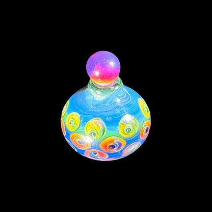 Colorful glass carb cap with blue swirls, yellow and orange accents on black background