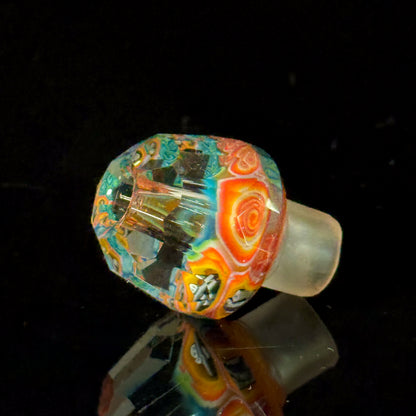 Colorful faceted glass bowl with intricate patterns on a black background