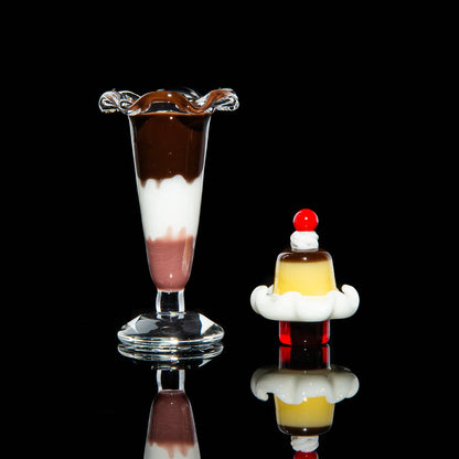Dessert-themed glass carb caps for dab rigs, shaped like a parfait and pudding, on black background