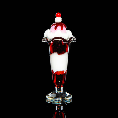Glass sundae carb cap with red and white swirl, shaped like ice cream on black background.