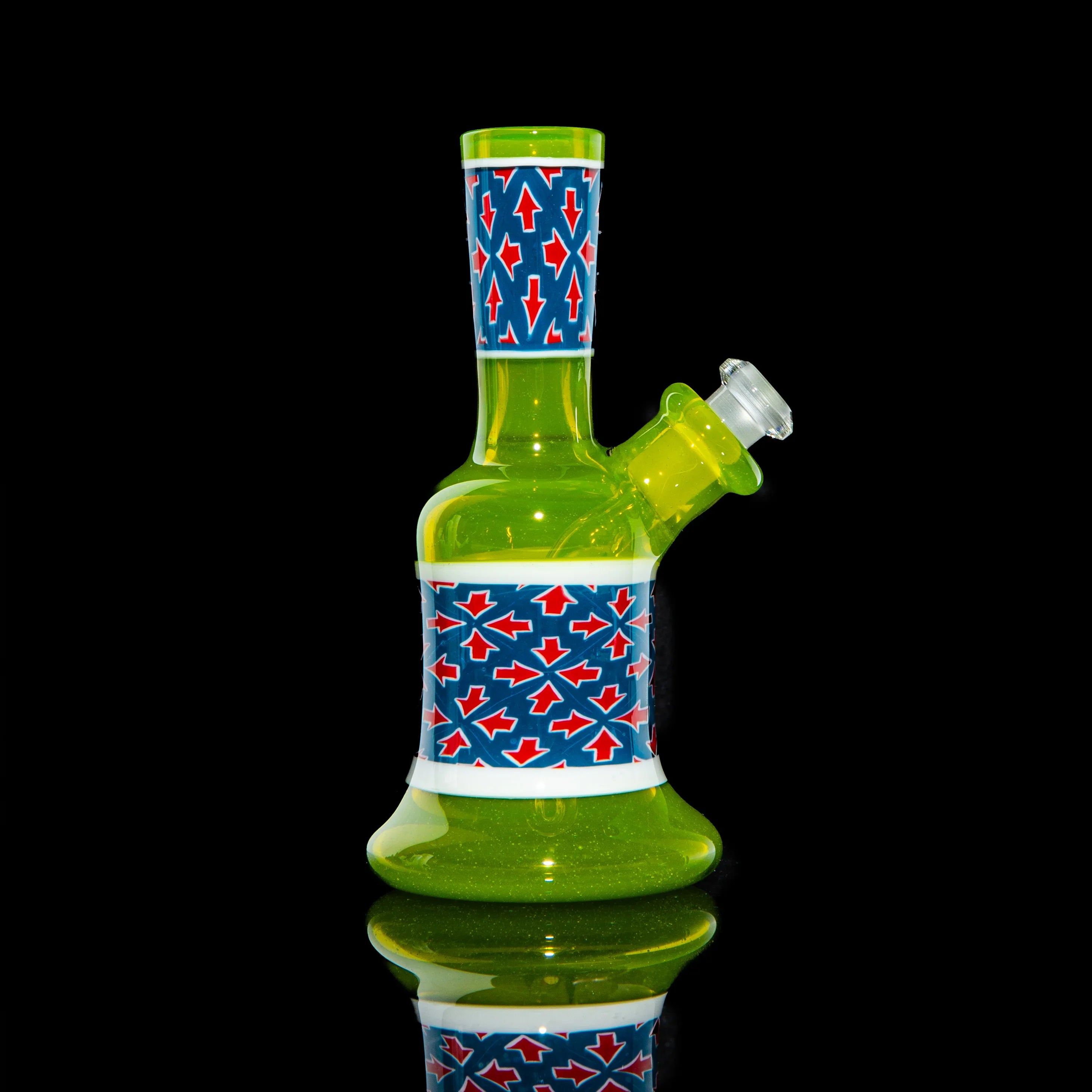 Green glass mini bong with blue, red, and white arrow pattern accents on a black background.