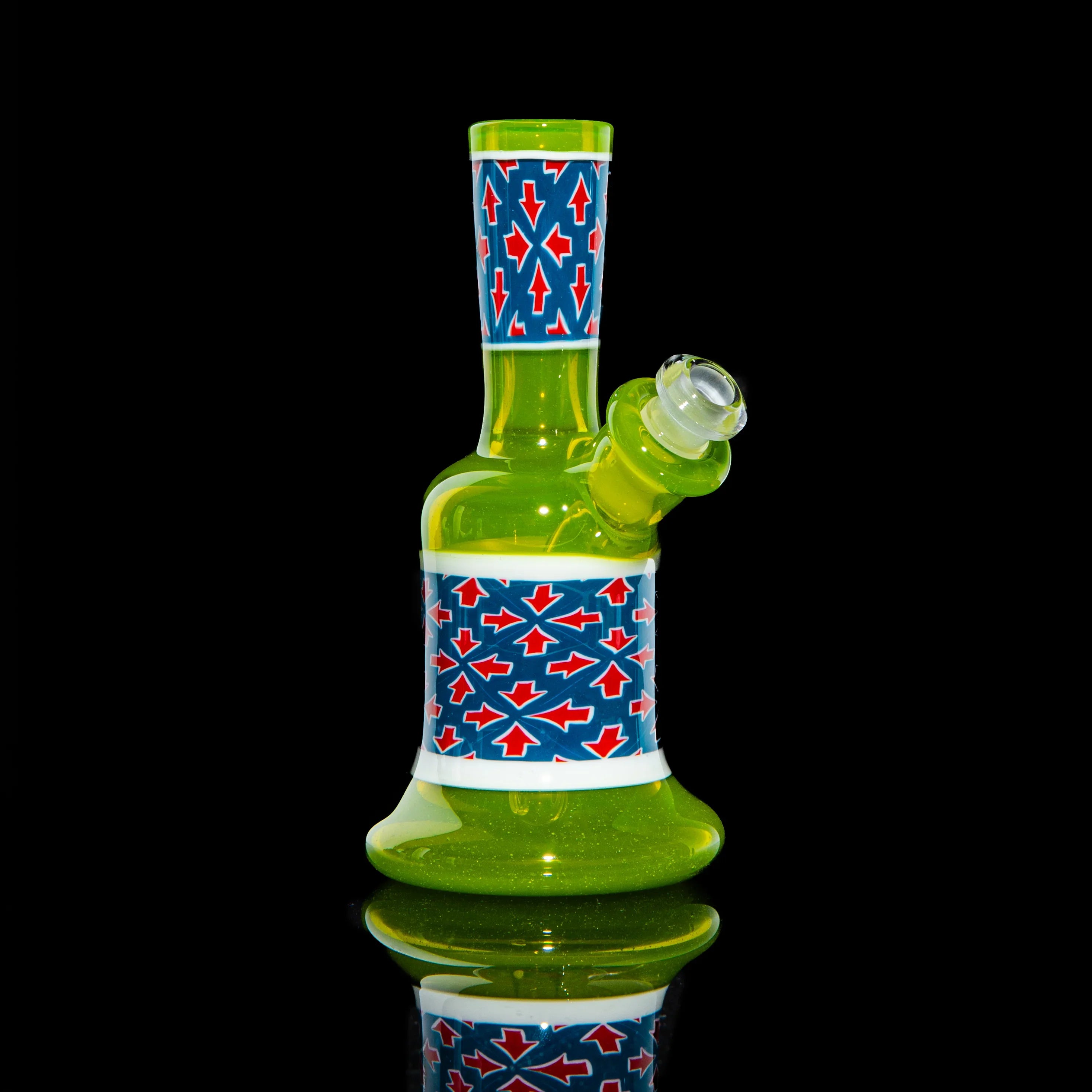 Green mini glass water pipe with red and blue geometric pattern on black background