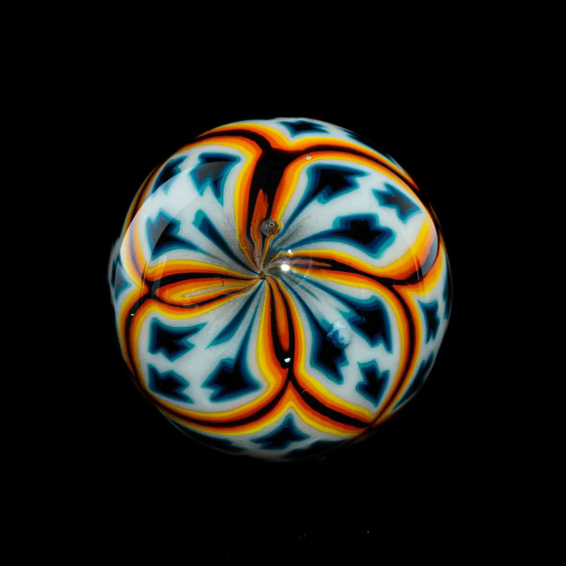Colorful glass marble with intricate orange, blue, and white patterns on black background