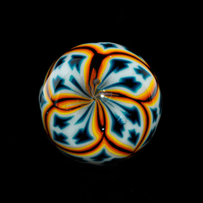 Colorful glass marble with intricate orange, blue, and white patterns on black background