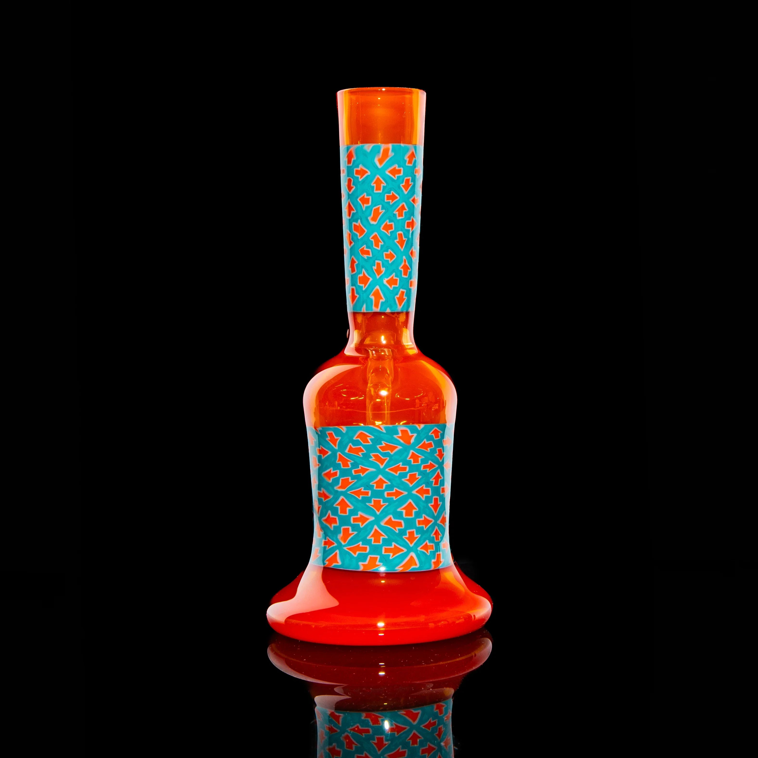 Orange glass mini tube with blue geometric patterned accents on black background