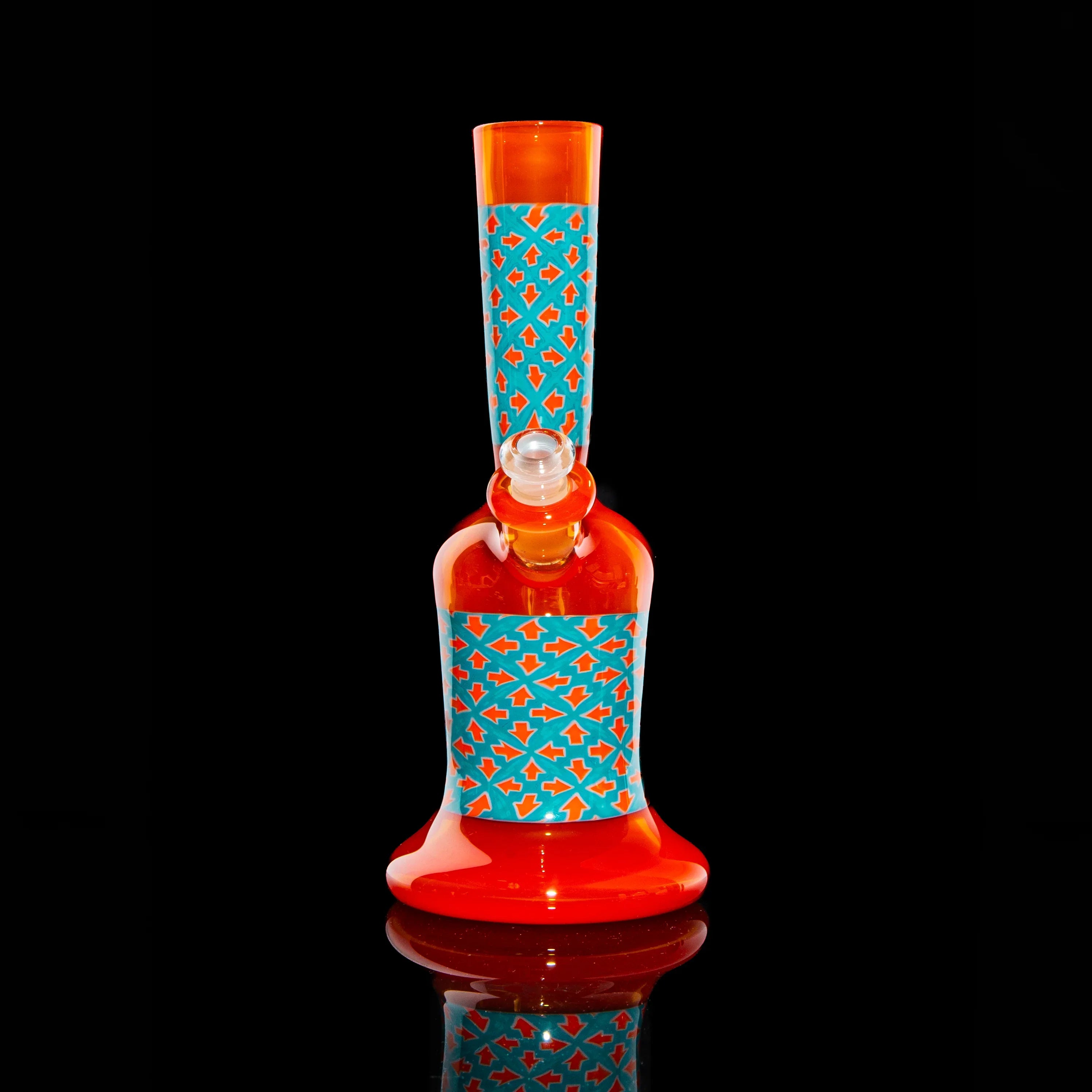 Red and orange glass water pipe with blue geometric pattern on black background