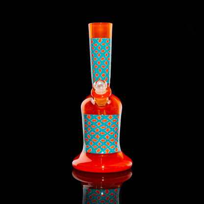 Red and orange glass water pipe with blue geometric pattern on black background