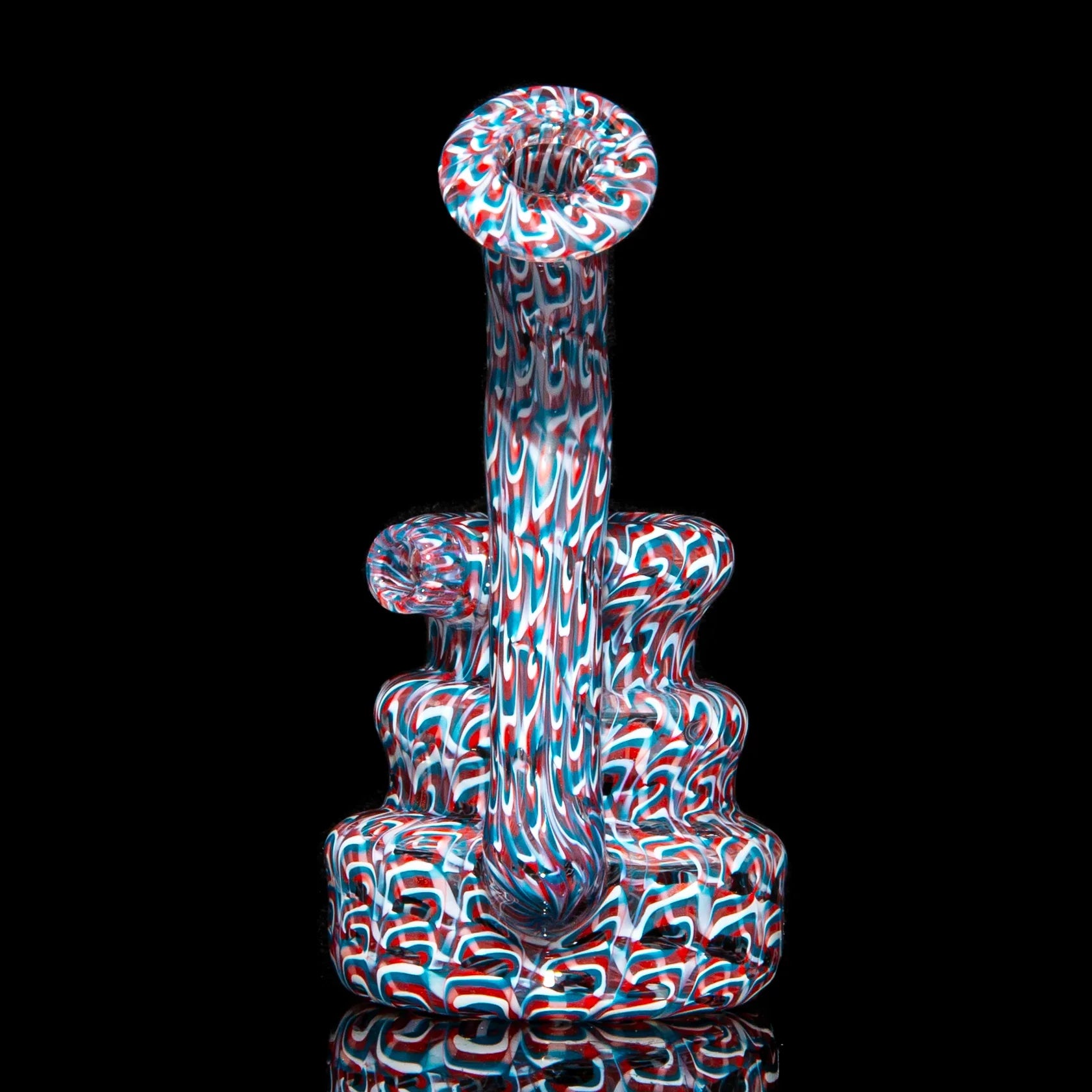 Colorful heady glass water pipe with intricate red, white, and blue swirling patterns