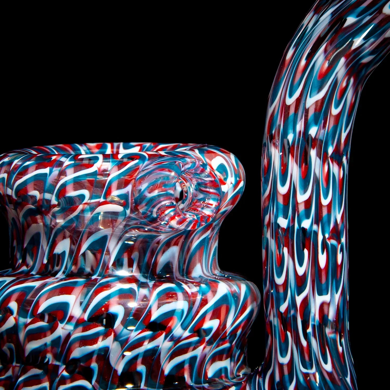 Heady glass water pipe with red, white, and blue swirl pattern on black background