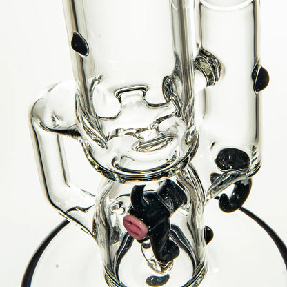 Close-up of a clear glass water pipe with black accents and artistic glasswork details